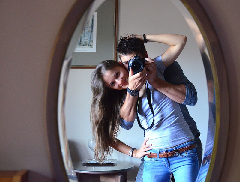 Man and woman posing together in a mirror