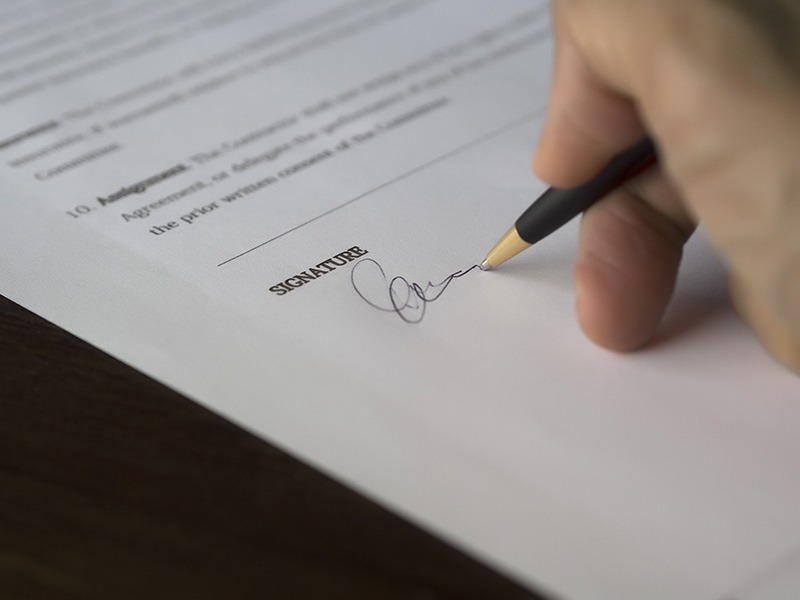 close-up of a hand signing a piece of paper